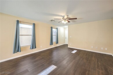 Empty room featuring ceiling fan, dark LVP floorin