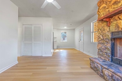 Unfurnished living room featuring baseboards, ligh
