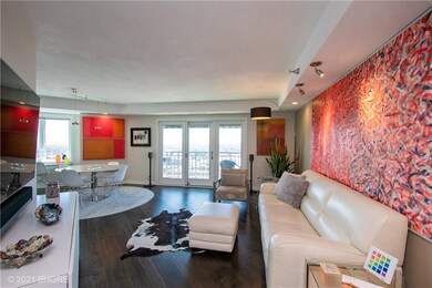 Main living area wood flooring & city views out al