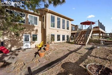 Back of house with stairs, stucco siding, and a wo