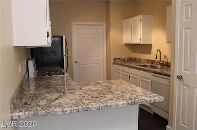 Kitchen featuring dishwasher, light stone counters
