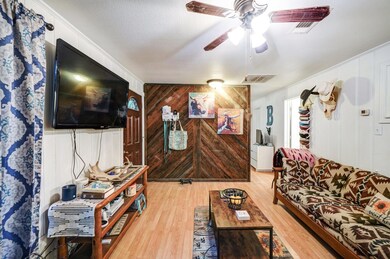 Living room featuring ceiling fan, wooden walls, h