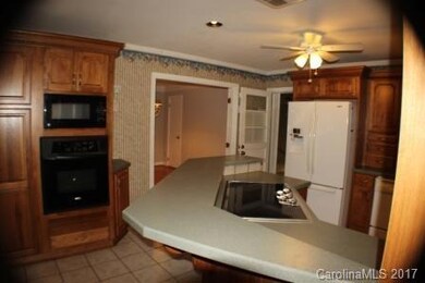 Tile floors, crown molding, tons of cabinet space, wall oven, microwave, electric cooktop, dishwasher, disposal, breakfast bar, this kitchen has it all!