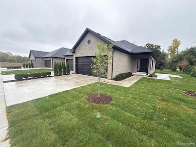 View of front facade featuring brick siding, driveway, and a front yard