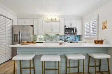 Kitchen with white cabinets, appliances with stain