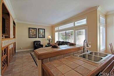 Kitchen has a eat at bar, tile counters and New St