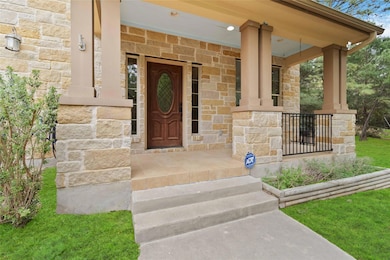 Doorway to property with stone siding and a porch