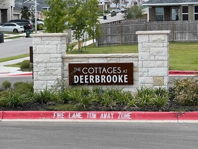 Community sign with fence and a residential view