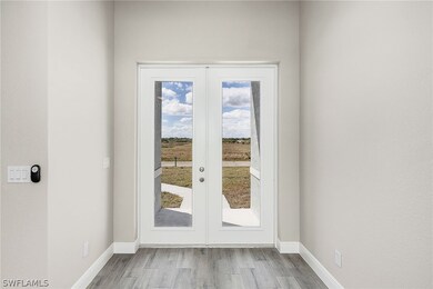 Doorway with french doors and light hardwood / woo