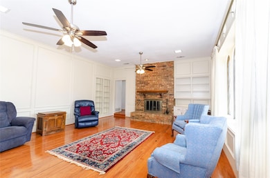 Living room with wood finished floors, built in fe