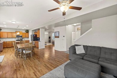 Living room with ceiling fan and light hardwood / 
