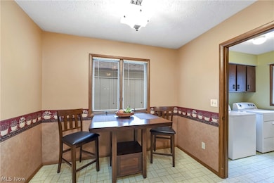 Dining room featuring  a textured ceiling, and light floors
