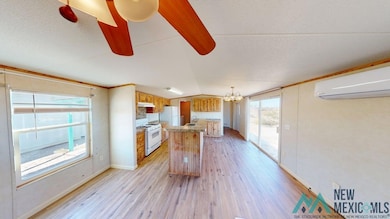Kitchen featuring light wood-style flooring, a chandelier, lofted ceiling, white gas stove, and light countertops