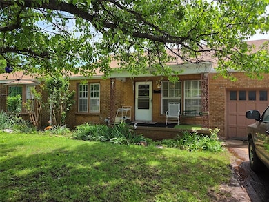 Ranch-style home with a porch, brick siding, an at