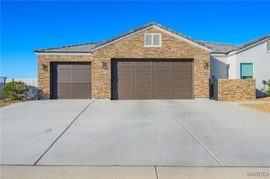Ranch-style home featuring driveway, stone siding,