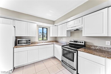 Kitchen featuring white cabinets, light tile patte