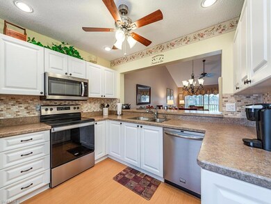 Kitchen featuring lofted ceiling, sink, white cabi