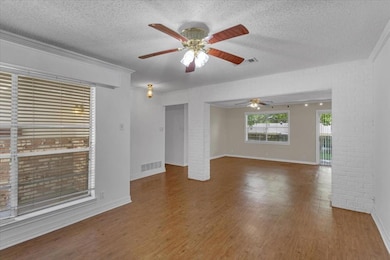 Unfurnished room featuring ceiling fan, hardwood / wood-style floors, and a textured ceiling