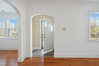 Foyer with ornamental molding and wood-type floori