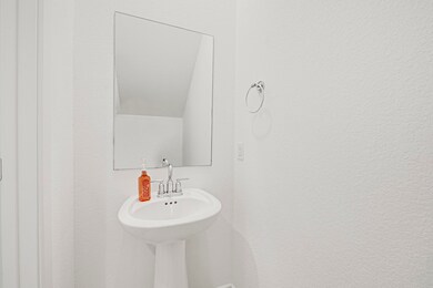 Compact half bath featuring a pedestal sink, chrom