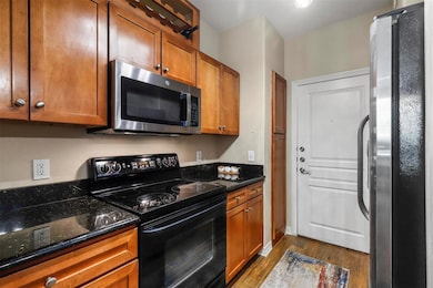 Kitchen featuring dark wood-style flooring, stainl