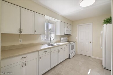 Kitchen with a sink, white appliances, light count