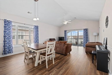 Dining room featuring dark wood-style floors, a ceiling fan, and lofted ceiling