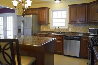 Updated kitchen opens to dining room with french doors leading to a large deck.
