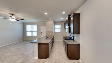 Kitchen featuring light tile patterned flooring, ceiling fan, stainless steel appliances, decorative backsplash, and sink