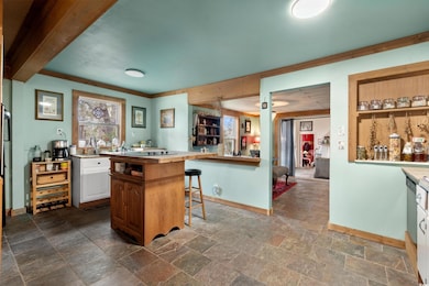 Kitchen with baseboards, a breakfast bar area, lig