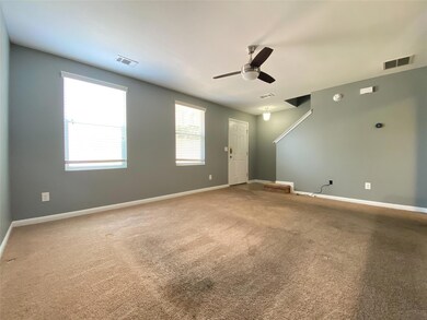 Carpeted empty room featuring ceiling fan and bas