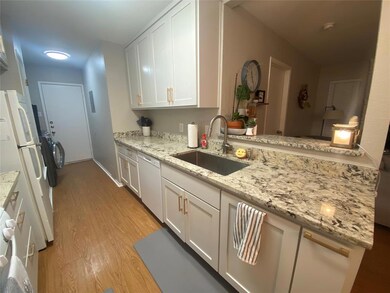 Kitchen featuring a sink, white appliances, light