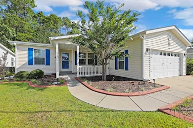 Single story home with a garage, concrete driveway, a front yard, and covered porch