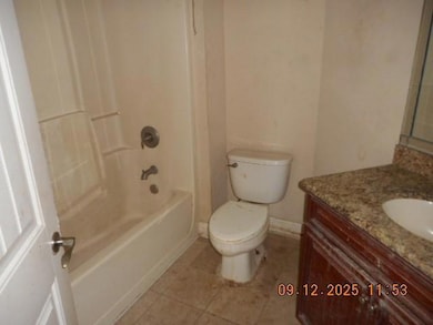 Bathroom with vanity, light tile patterned floors, and shower / bathtub combination
