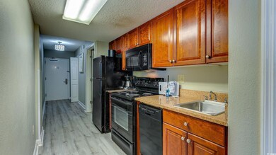 Kitchen featuring black appliances, sink, light st