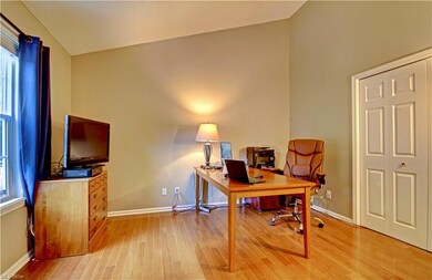 Office area with light hardwood flooring, vaulted ceiling, and a healthy amount of sunlight