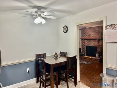 Dining space featuring a brick fireplace, ceiling fan, and light wood-type flooring