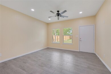 Empty room with a ceiling fan, light wood-type flo