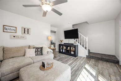 View of family room, stairs to second level, hall to kitchen, breakfast and full bath