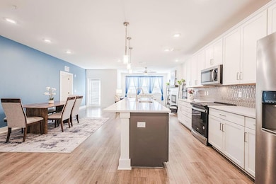 Kitchen with an island with sink, a sink, backspla