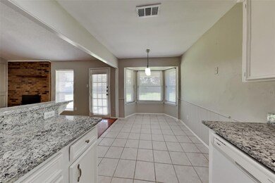 Kitchen with white cabinetry, light tile patterned