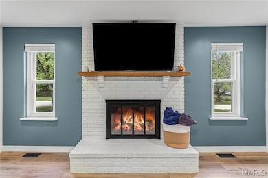 Detailed view of wood finished floors and a brick fireplace