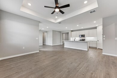 Unfurnished living room with a tray ceiling, recessed lighting, and light wood-type flooring