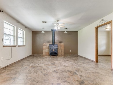 Unfurnished living room with a wood stove, a ceili