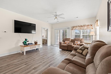 Living room featuring ceiling fan, baseboards, and wood finished floors