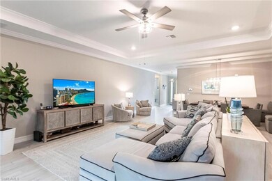 Living room with crown molding, a tray ceiling, li
