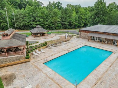 View of pool with a gazebo, a patio area, and a wooded view