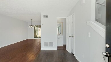 Empty room featuring a chandelier, dark wood-type 