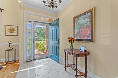 Foyer featuring crown molding, light tile patterned flooring, and a chandelier