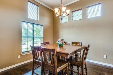The formal dining features a wood floor, crown mol